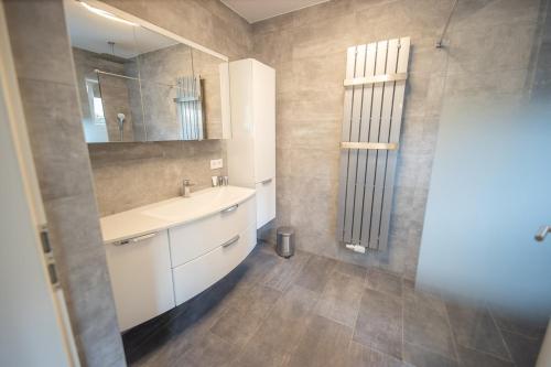 a bathroom with a sink and a mirror at Lakeside Diamond Apartment - Krumpendorf in Krumpendorf am Wörthersee