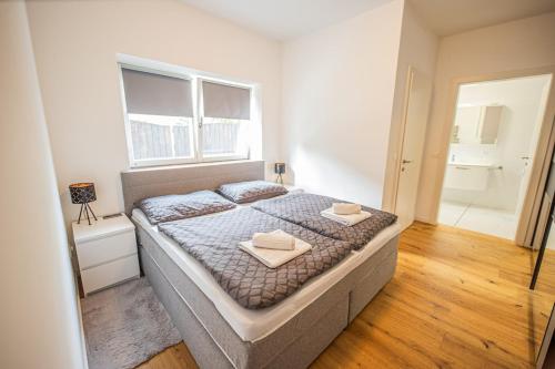 a bedroom with a bed with two towels on it at Lakeside Diamond Apartment - Krumpendorf in Krumpendorf am Wörthersee