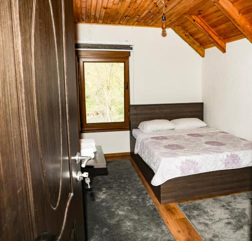 a bedroom with a bed and a window at Modra Rijeka Resort in Glavatičevo