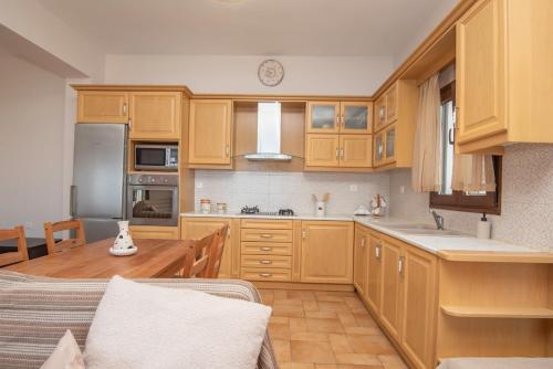 a large kitchen with wooden cabinets and a table at Sonias Point of View in Myrties