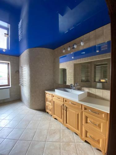 a bathroom with a sink and a blue ceiling at Castle Apartments in Schaslyve