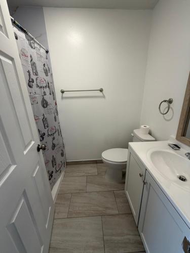 a white bathroom with a toilet and a sink at Rivers Inn in Fort Madison