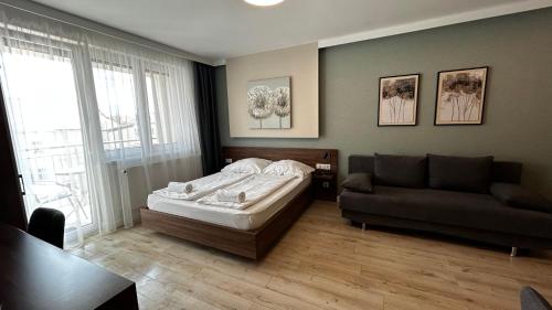 a bedroom with a bed and a couch at Hatvan Central Apartment in Debrecen