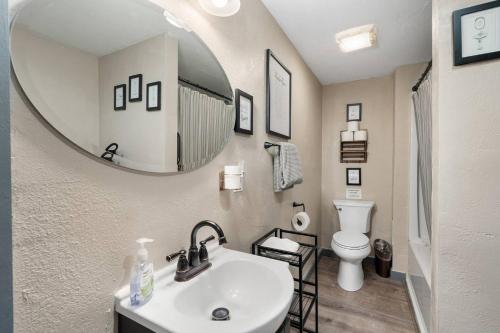 a bathroom with a sink and a mirror and a toilet at Modern Pet-Friendly Cottage - Graystone Retreat in Prescott