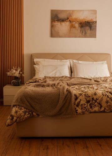 a bedroom with a bed with a blanket and pillows at Xhejn's Veranda 7 in Durrës