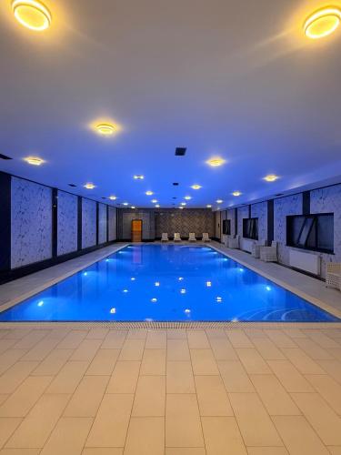 a large swimming pool with blue water in a building at Art Royal in Tashkent