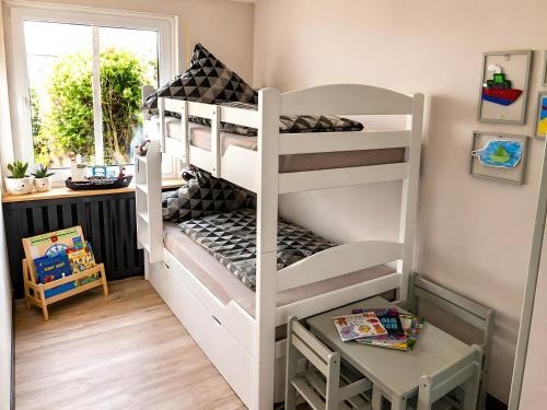 a white bunk bed in a room with a window at Buddelhuus in Norddeich