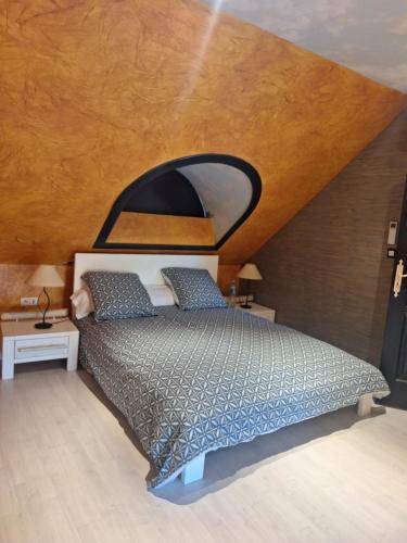 a bedroom with a bed with a wooden ceiling at Chambres à 10 min du circuit des 24h en campagne in Guécélard