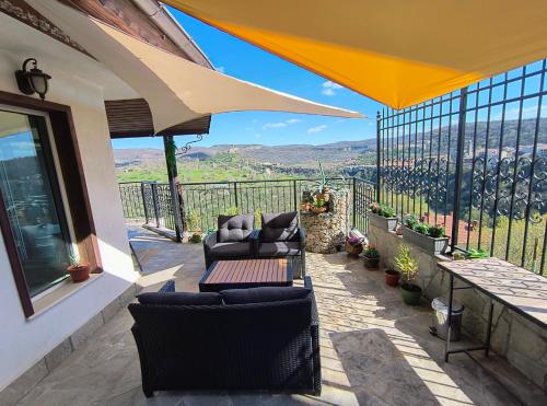 a patio with couches and chairs on a balcony at House 46 in Veliko Tŭrnovo