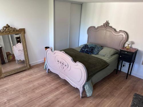 a pink bed in a room with a mirror at Le Grain d Or in Blois