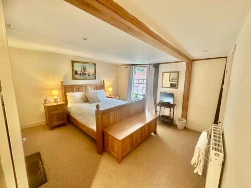 a bedroom with a bed and a desk and a window at Manor Cottage in Cavendish