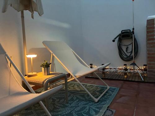 a white chair and a table in a living room at Nuestro lugar feliz Apartamento Barbate - Patio ducha exterior in Barbate