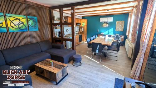 a living room with a couch and a table at Arode Lodge Blick auf Zorge - Mountain Lodge with Panoramic Views in Zorge