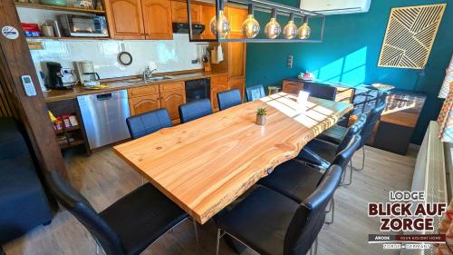 a large wooden table in a kitchen with chairs at Arode Lodge Blick auf Zorge - Mountain Lodge with Panoramic Views in Zorge