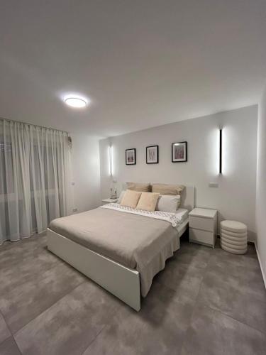 a white bedroom with a large bed in it at MelSun Apartment in Melsungen