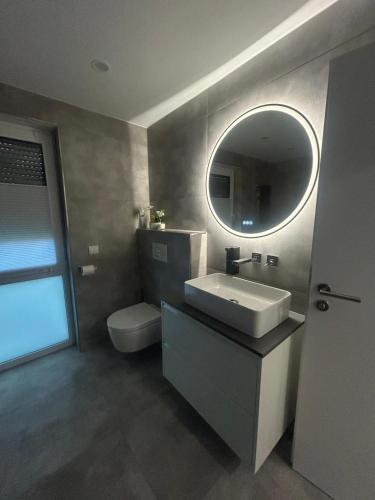 a bathroom with a sink and a mirror at MelSun Apartment in Melsungen