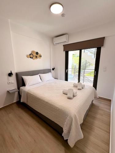 a bedroom with a large bed with towels on it at Solmare Apartments in Nikiana