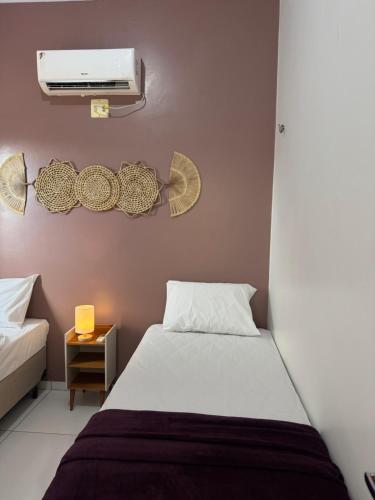 a bedroom with a bed and a air conditioner at Professor Guest House in Santo Amaro