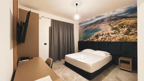 a hotel room with a bed and a painting on the wall at Hotel Ruko Boutique Deluxe in Golem