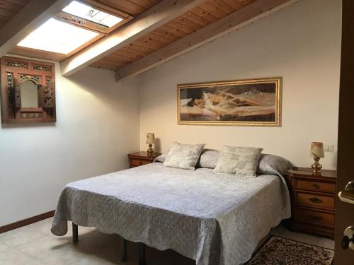 a bedroom with a bed and a painting on the wall at Residence The Cherry House - Appartamenti con piscina in Carro
