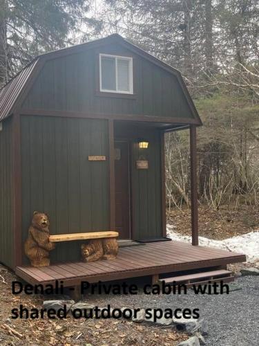 a teddy bear sitting on a porch of a shed at Sometimes Creek Cabins in Seward