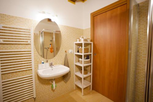 a bathroom with a sink and a mirror at Casa Azzurra - Spacious apartment in the heart of Julian Alps in Cave del Predil