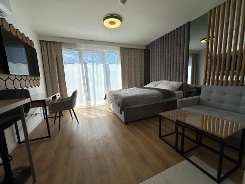 a living room with a bed and a desk at LUXURY Portovo in Gdańsk