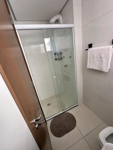 a shower with a glass door in a bathroom at Apartamento 83 - Carmelo in Ribeirão Preto