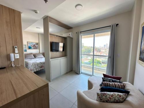 a living room with a couch and a bedroom at Apartamento 83 - Carmelo in Ribeirão Preto