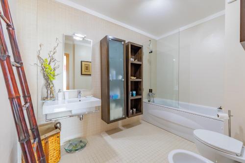a bathroom with a sink and a toilet and a mirror at Sesimbra Mar Apartamento in Sesimbra