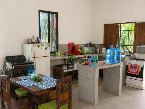a kitchen with a table and a refrigerator at Chichicoland in Tena