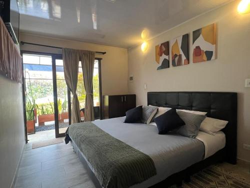 a bedroom with a large bed and a sliding glass door at Posada Tierra Viva - Villa de Leyva in Villa de Leyva