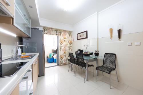 a kitchen with a table and chairs in a room at Sesimbra Mar Apartamento in Sesimbra