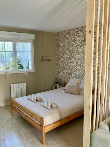 a bedroom with a bed with a wooden frame at Abri 82 in Picauville