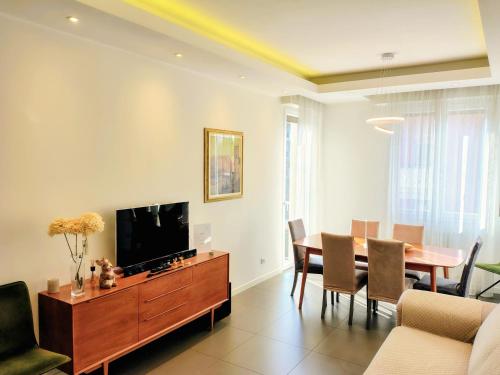 a living room with a dining table and a television at The Twins Suite & Hub in Monza