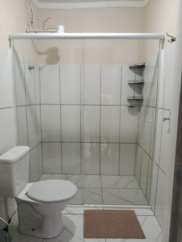 a white bathroom with a shower with a toilet at hospedagem da rosa in Morretes