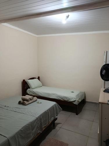 a room with two beds and a light on the ceiling at hospedagem da rosa in Morretes