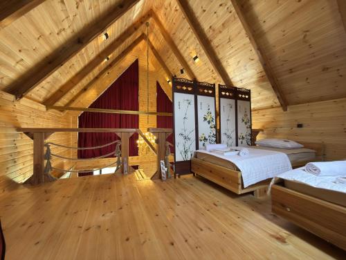 a bedroom with two beds in a wooden house at Bondo'S Cottage in Kobuleti