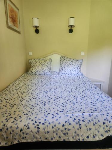 a bedroom with a blue and white bed with two lights at Residence de bordaberry in Urrugne