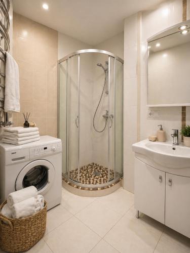 a bathroom with a shower and a washing machine at Apartamentai Palangoje Arune in Palanga