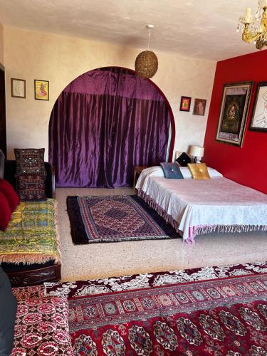 a bedroom with a large bed with a purple canopy at Mandala Chai Studios in Mellieħa