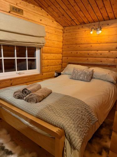 a bedroom with a bed in a log cabin at Beautifully Restored Log Cabin in Trawsfynydd