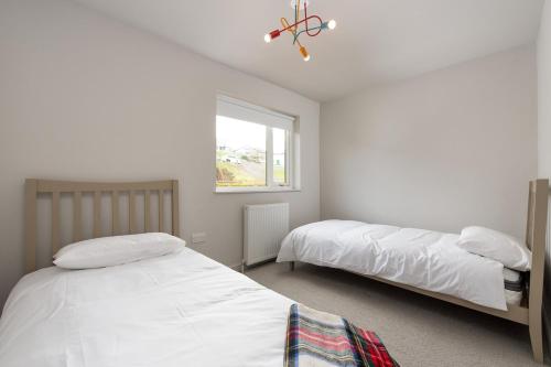 a bedroom with two beds and a window at Murray Cottage in Gardenstown