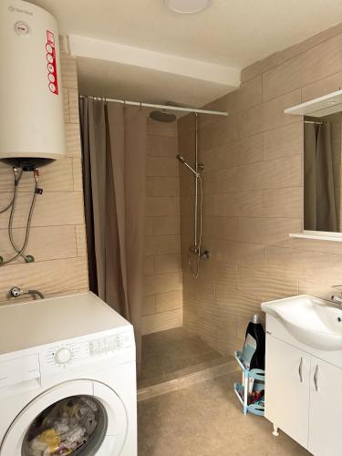 a washing machine in a bathroom with a shower at Guesthouse Idea in Vusanje
