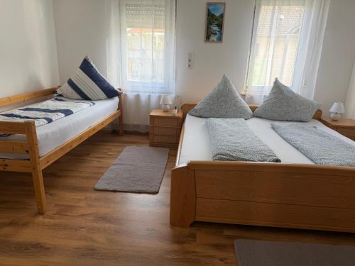 two beds in a room with wooden floors and windows at Dürschgangs Zimmer in Siegen
