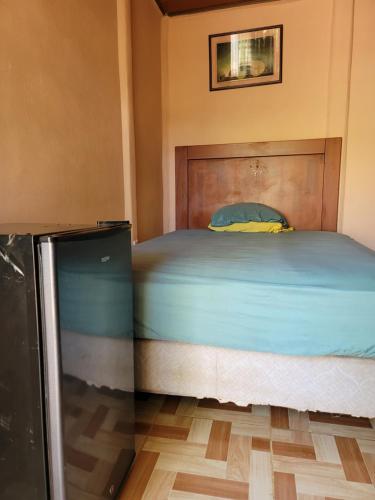 a bedroom with a bed with a wooden headboard at Alojamiento Artola para 4 personas in Sardinal