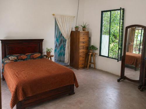 a bedroom with a bed and a dresser and a window at Chichicoland in Tena