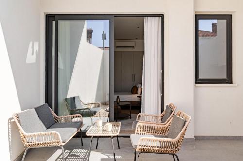 a group of chairs and a table on a patio at Yamas Urban Living Olympia Suites Old Town Studio in Limassol