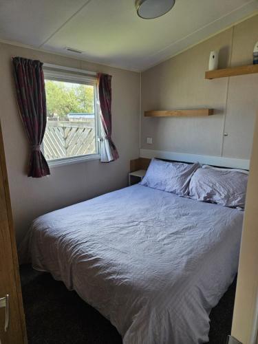 a bedroom with a bed and a window at PMH rental in Saint Osyth