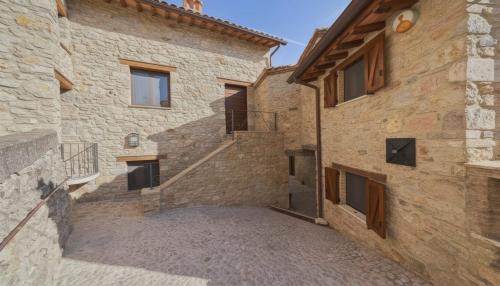 a stone house with a staircase in the side of a building at La Casa di Nonna Iolanda in Gualdo Cattaneo